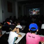 Niños viendo la película Encanto en pantalla grande