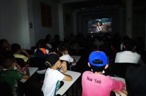 Niños viendo la película Encanto en pantalla grande