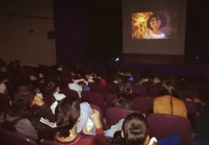 Niños viendo la película Encanto en pantalla grande