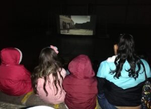 Niños viendo la película Encanto en pantalla grande