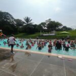 Niños jugando y realizando actividades deportivas en piscina con los papás