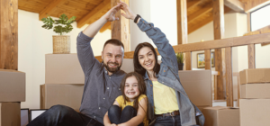 Familia feliz hace señal de hogar con sus manos y resguardan a su hija
