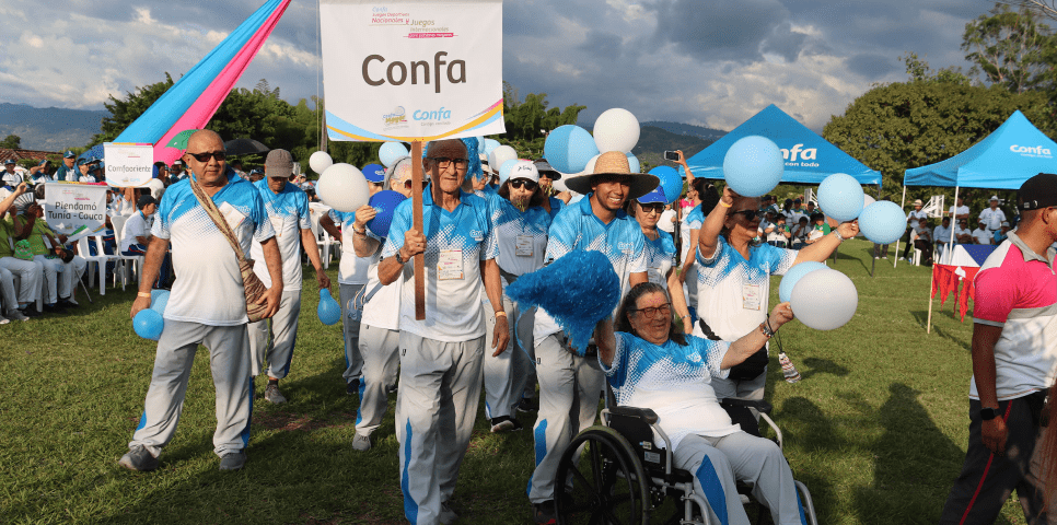 Desfile de adultos mayores con uniformes deportivos de confa