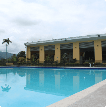 Piscina con edificio de restaurante al fondo