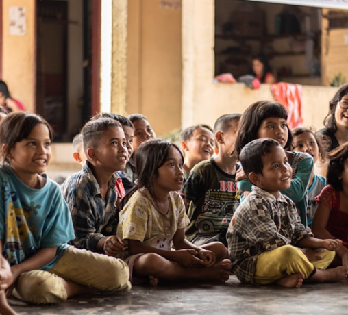 Niños sentandos en el suelo descalzos