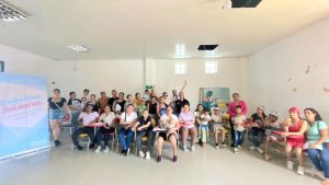 Grupo grande de personas con bebes en un salon para recibir capacitacion de Confamilias solidarias