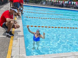 Mujer mayor celebrando en la piscina al terminar la competencia en los Juegos de Adultos Mayores de Confa