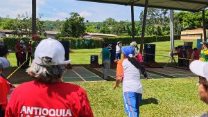 Personas juegan tejo en los juegos deportivos de adultos