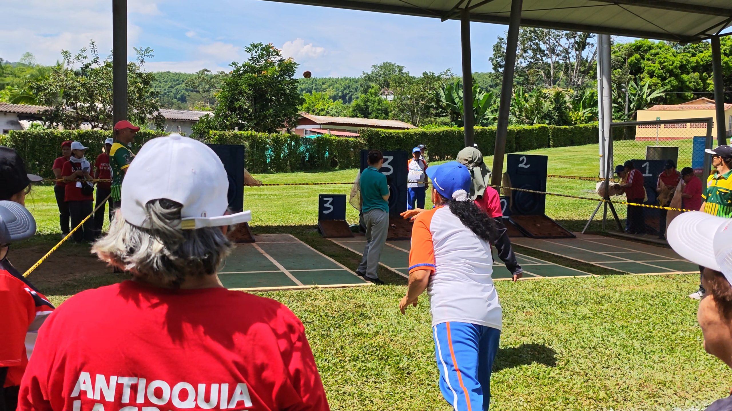 Personas juegan tejo en los juegos deportivos de adultos