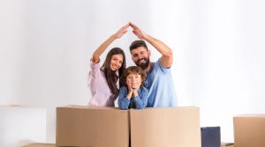 Una familia feliz construye casa con sus brazos. Motiva por el subsidio de vivienda de Confa