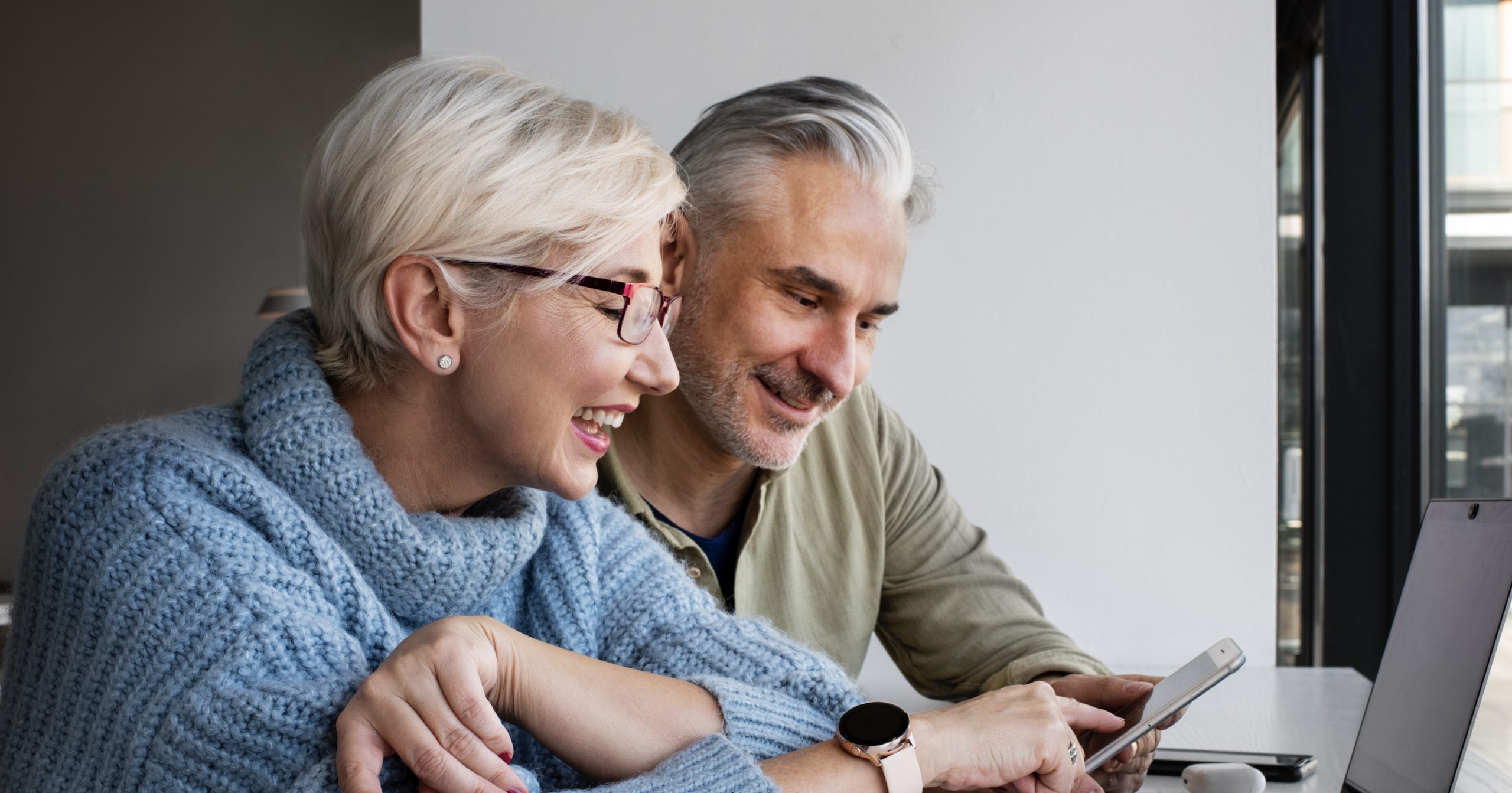Dos personas, hombre y mujer, adultas, sonrién mientras solicitan su crédito en Confa