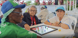 Personas mayores juegan parqués en los juegos de personas mayores de Confa